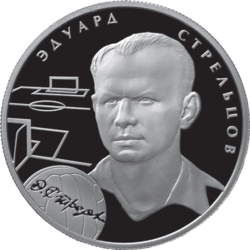 A silver coin with Strelstov’s head and neck illustrated in relief upon it, accompanied by the outlines of a football pitch and a football and his name in Russian.